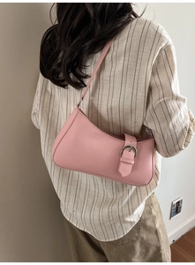 Detail of pink crescent underarm bag showing silver buckle and smooth leather texture