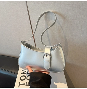 Detail shot of metallic silver crescent bag with retro Y2K buckle and mirror finish leather