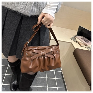 Detail of caramel pleated tote bag with bow accent and star metal rivet embellishment