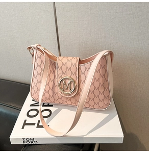 Close-up of pink hobo bag featuring M letter print and round golden logo buckle
