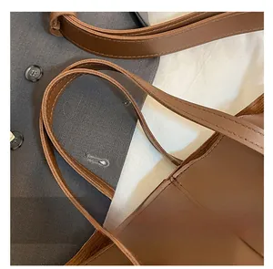 Detailed shot of brown leather double straps with fine stitching on a large tote bag