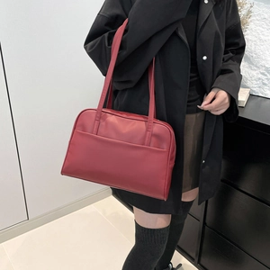 Minimalist red oversized shoulder tote bag with front pocket shown on a model