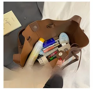 Spacious interior of brown faux leather tote bag with magnetic closure and cosmetics