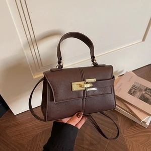 Brown lychee leather trapezoid handbag with gold buckle and adjustable strap