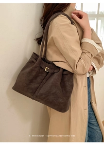 Dettaglio borsa tote marrone scuro con fibbia dorata e finitura opaca con texture