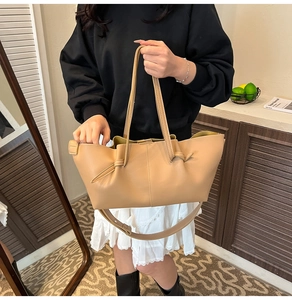 Detail of the khaki pleated tote bag showing matte leather texture and knotted handle