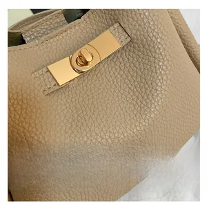 Detail of elegant gold rectangular twist lock on apricot lychee pattern leather bag