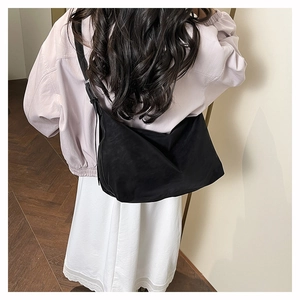 Model showing a black crossbody dumpling bag in high-quality matte fabric for daily use