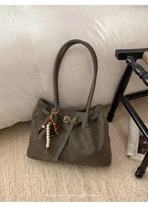 Dettaglio della borsa tote verde oliva con morbida pelle e ciondolo di perline vintage