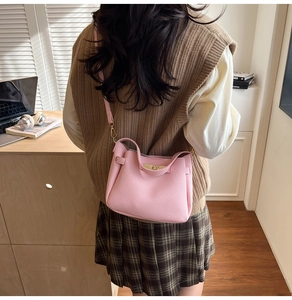 Détail du sac seau rose en cuir grainé avec boucle rotative en métal doré clair