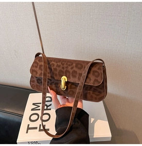 Détail du sac à bandoulière léopard avec fermoir tournant doré et fine lanière élégante