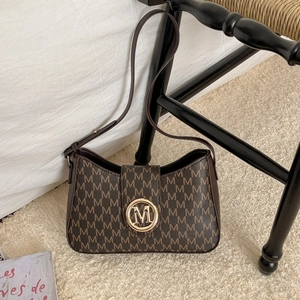 Vintage brown shoulder bag with saddle shape and monogram M pattern in high-quality leather