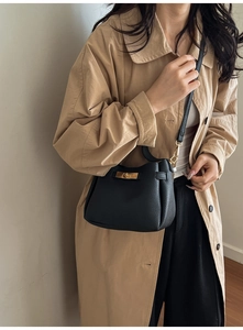 Détail du sac seau en cuir grainé noir avec fermoir rotatif métallique doré brillant