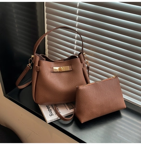 Détail du sac seau en cuir marron foncé avec fermoir doré et sa pochette assortie