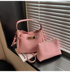 Détail du sac seau en cuir rose à grain avec accessoires métalliques dorés chic