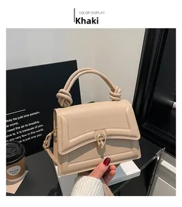 Detail of khaki leather handbag featuring knotted handle and gold metal ring lock