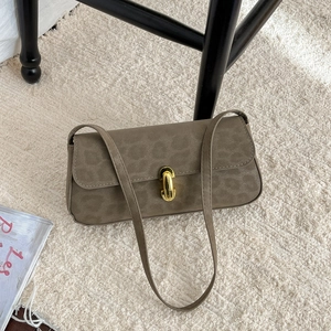 Leopard print baguette bag with gold twist lock on beige carpet, minimalist retro style