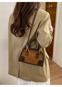 Borsa Boston retrò in pelle scamosciata smerigliata indossata da modella con tailleur