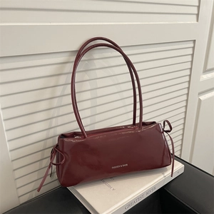 Elegant deep wine red baguette bag with bow details and polished leather finish