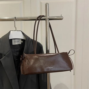 Deep brown glossy leather baguette bag with a chic side bow and fashion lettering