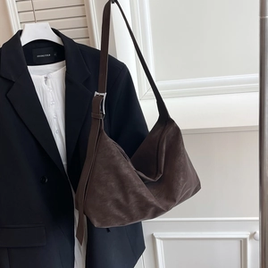 Deep brown vintage suede hobo bag with adjustable strap shown in a minimalist setting