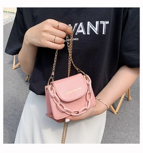 Detail of pink mini crossbody bag with gold chain and thick decorative links
