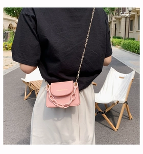 Pink mini crossbody bag with metal chain strap and bold plastic link detail decoration