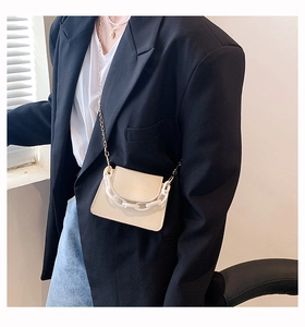 Detail of cream mini crossbody bag with gold chain and white chunky plastic handle