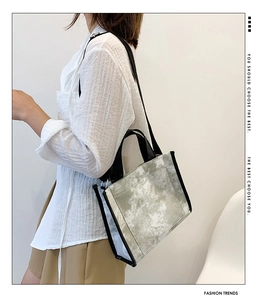 Detail shot of a canvas tote bag with gray marble tie-dye pattern and black straps