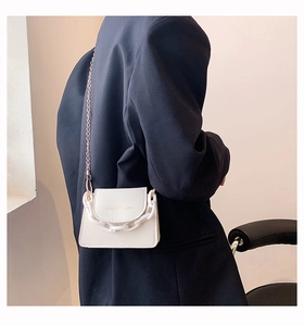 Chic white mini crossbody bag with thick acrylic chain detail shown on a black blazer