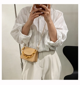 Mini crossbody bag in beige PU leather featuring a vibrant yellow chain strap detail
