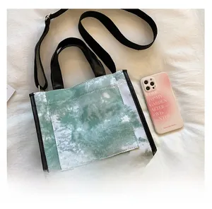 Detail of green marble tie-dye canvas tote with adjustable strap and front pocket
