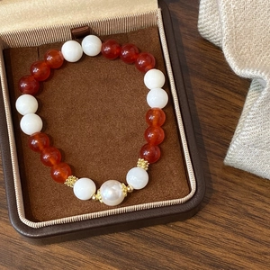 Retro style bracelet with red agate beads, white jade beads, and a large central pearl