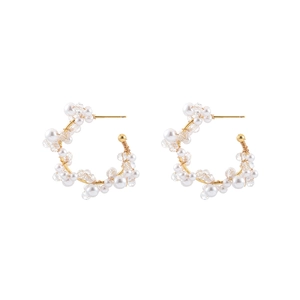 Elegant gold earrings with white pearls and crystal beads on a white background