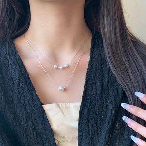 Elegant double-layer pearl necklace with silver chain on model, minimalist choker style