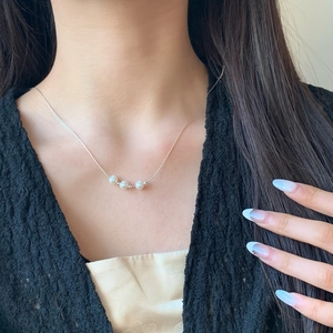 Elegant minimalist silver necklace with three round white pearls on a slim metal chain