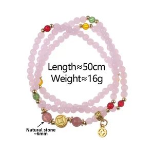 Macro shot of 50cm natural stone bead bracelet with purple crystals and gold coin charm
