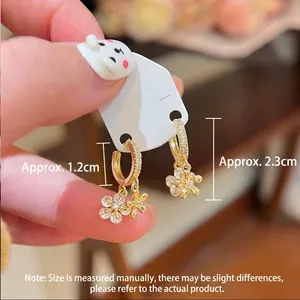 Detailed view of 18K gold floral earrings with zircon micro-pave detailing, length 2.3cm
