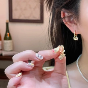 Elegant gold flower drop earrings with small white crystals and a center pearl detail