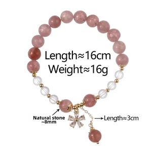 Detail of pink natural stone beaded bracelet with gold flower pendant on white background