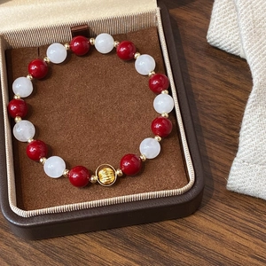Handmade beaded bracelet with red pearls, white natural stones and gold-plated hollow charm