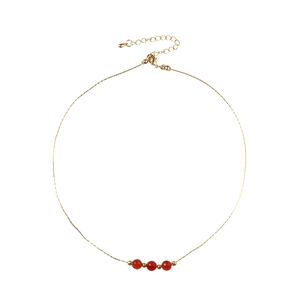 Minimalist gold chain necklace with three red beads and adjustable lobster clasp closure