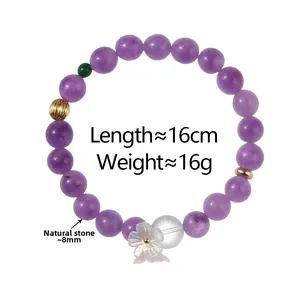 Détail d'un bracelet en pierre naturelle violette 8mm avec breloque fleur et perles d'or