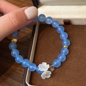 Élégant bracelet en perles bleu ciel avec breloques fleurs blanches et détails dorés