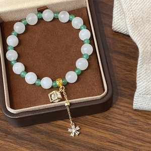 Bracelet élégant en perles blanches et vertes avec un pendentif en zircon doré