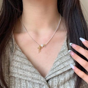Elegant gold bow necklace with white pearl pendant for women, minimalist style