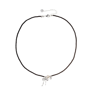 Elegant beaded necklace with silver bow pendant, white pearl and zircon on white background