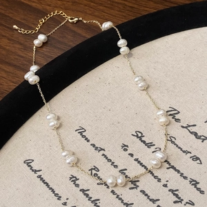 Élégant collier de perles d'eau douce plaqué or sur un fond vintage