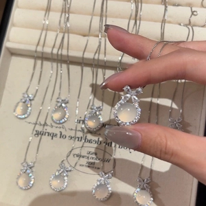 Detailaufnahme der Opal-Halskette mit Schleifenanhänger und vergoldeter feiner Kette