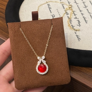 Elegante goldene Schleife-Halskette mit rotem Opal-Anhänger und Zirkonia-Akzenten